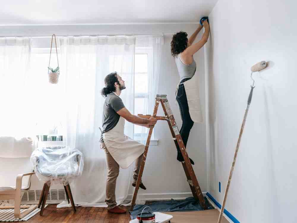 An image of a Gen Z couple working on their wall renovation. 