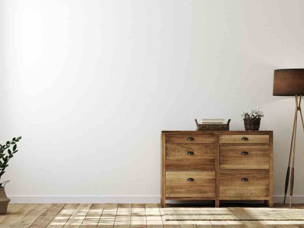 An image of a wooden drawer with a wicker basket on top. 