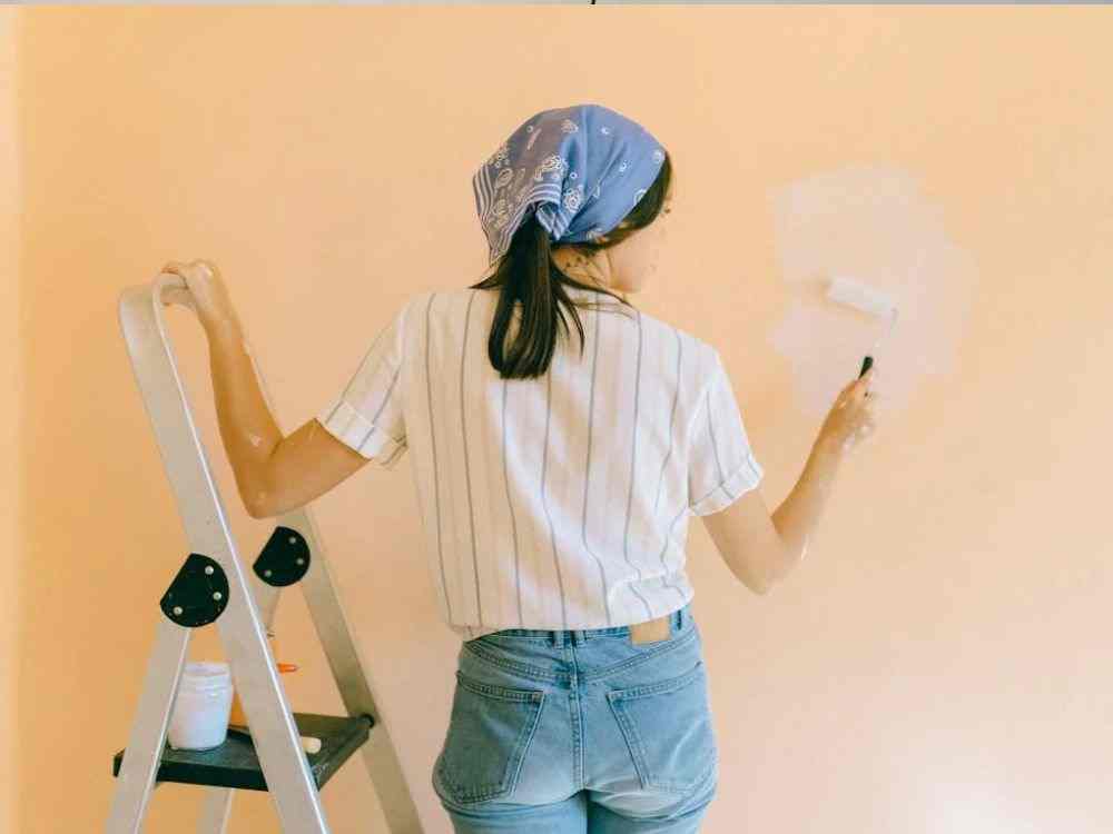 An image of a person applying paint onto a wall. 