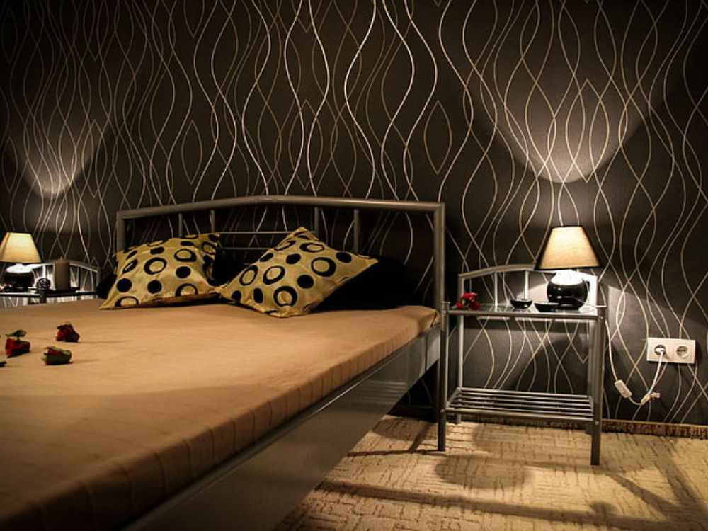An image of a black wallpaper with wavy line design on a bedroom wall.