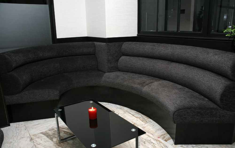 An image of curved black sofas.