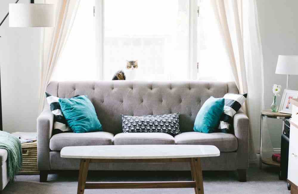 An image of a couch in front of a window. 