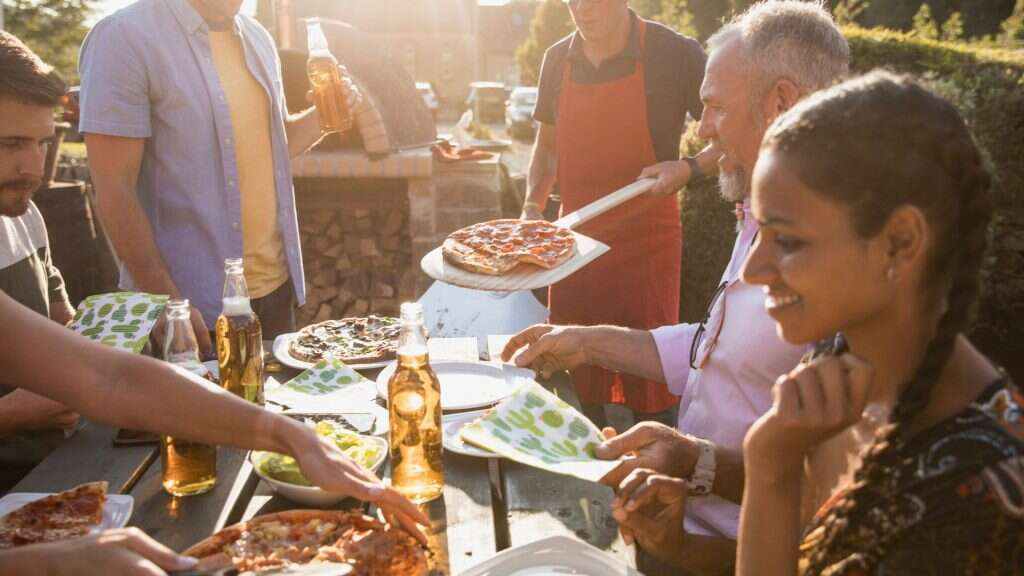 An image of people eating pizza for an article about growing a pizza garden.