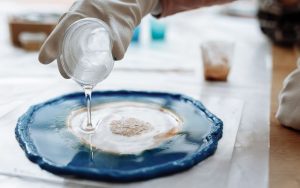 An image of resin being poured onto a medium to create resin art.