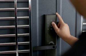 An image of a person opening a smart lock with numeric pads.