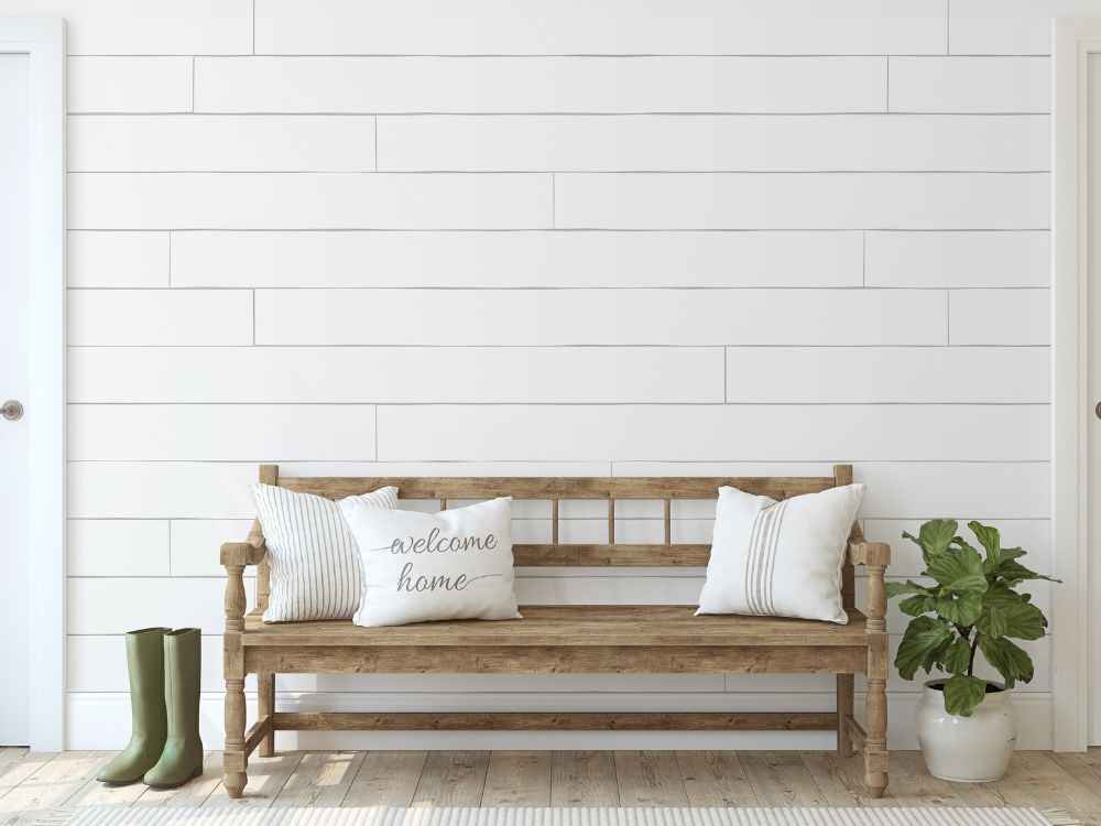 An image of a wooden couch with white pillows.